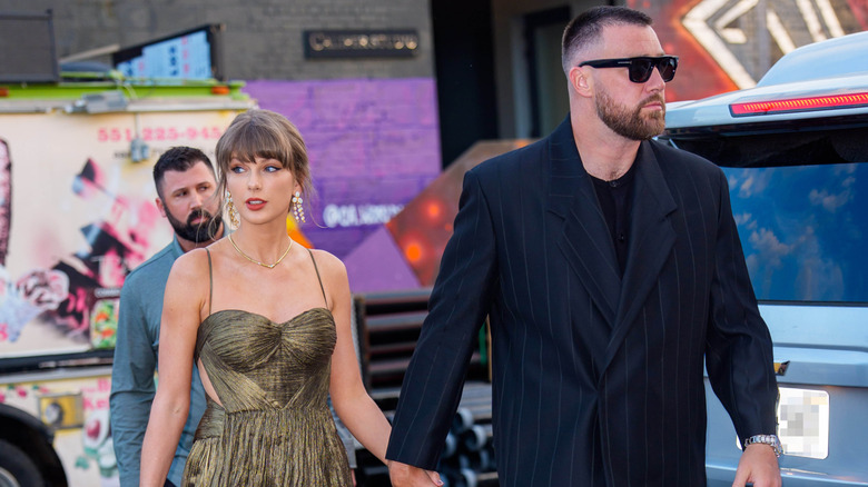 Taylor Swift and Travis Kelce walking while holding hands