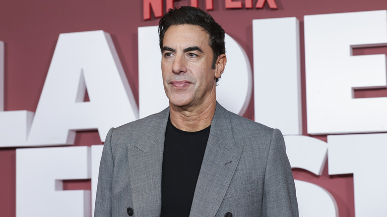 Sacha Baron Cohen grimacing on the red carpet