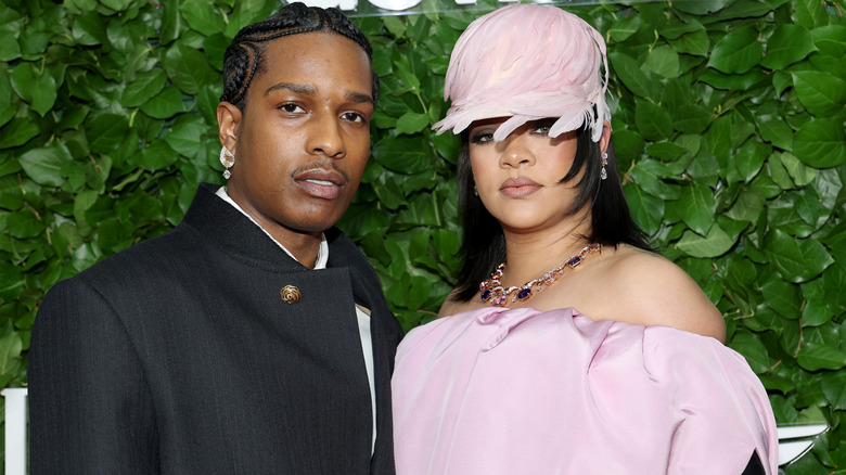 ASAP Rocky in a black coat and Rihanna ib a pink dress and feather hat