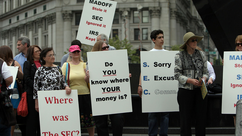 A group of people protesting in New York against Bernie Madoff