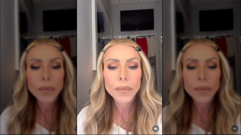 Kelly Ripa pouting her lips while looking in a mirror