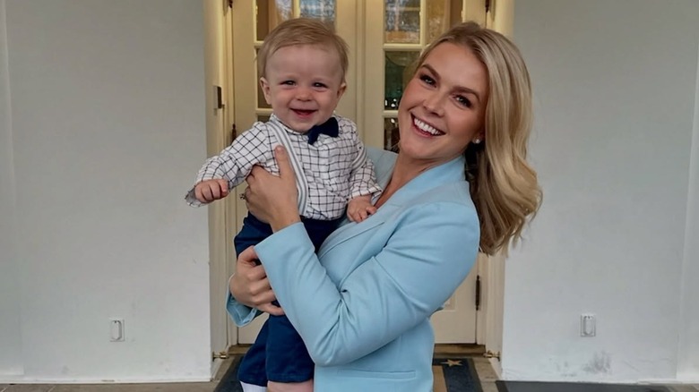 Karoline Leavitt smiling and holding her son