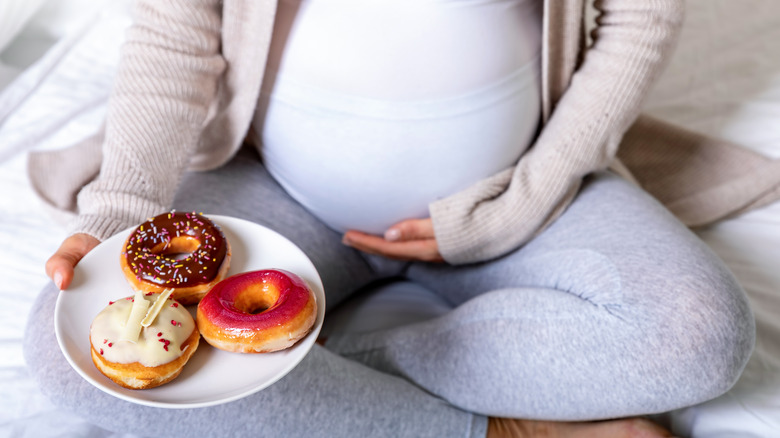 Pregnant woman with donuts 