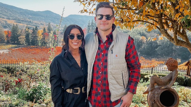 Chelsea and Cole DeBoer posing in front of a fall landscape