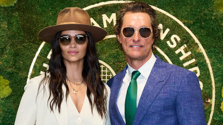 Camila Alves and Matthew McConaughey wearing sunglasses and suits
