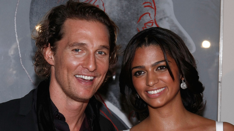 Matthew McConaughey wearing black and Camila Alves wearing a white dress