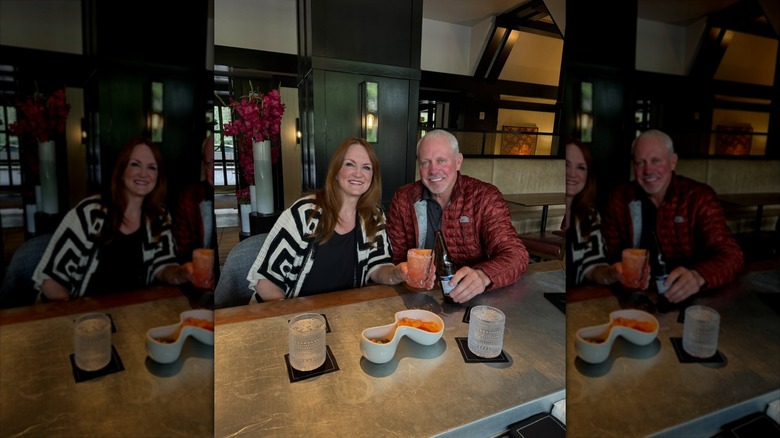Ree Drummond and Ladd Drummond inside restaurant with drinks in hand.