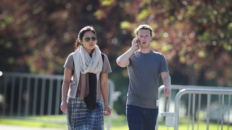 Mark Zuckerberg and Priscilla Chan walking together at a park