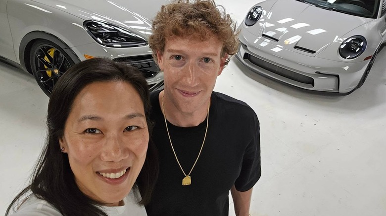 Mark Zuckerberg and Priscilla Chan posing in front of cars