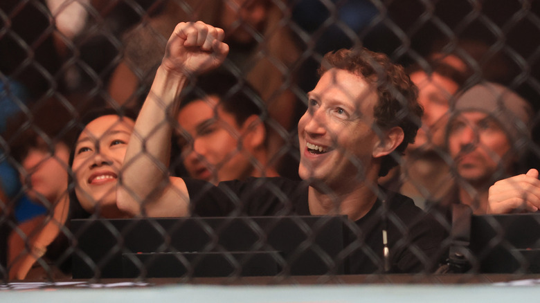 Mark Zuckerberg and his wife smiling outside a fighting ring