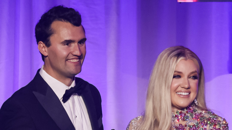 Charlie and Erika Kirk smiling while onstage at a glitzy event