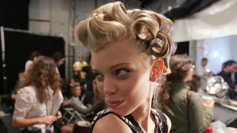 Woman wearing rollers in studio