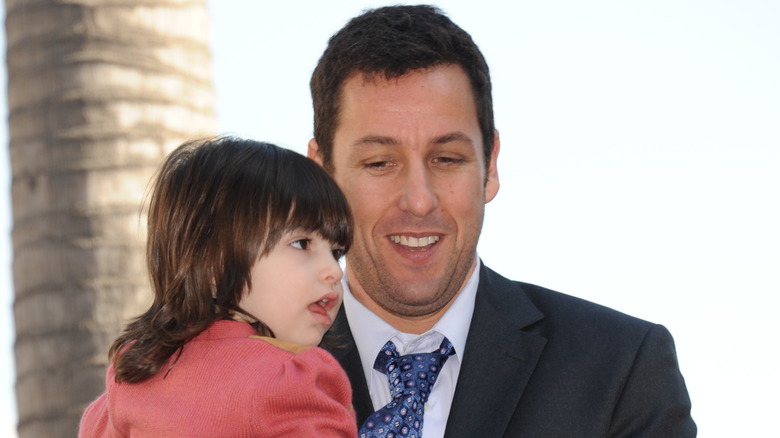 Adam Sandler holding his daughter Sunny