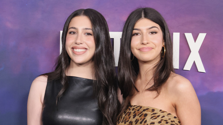 Sadie and Sunny Sandler pose on a red carpet
