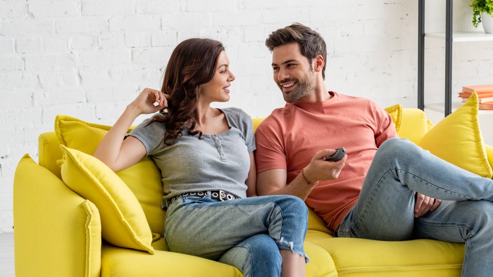 man and woman talking on a couch