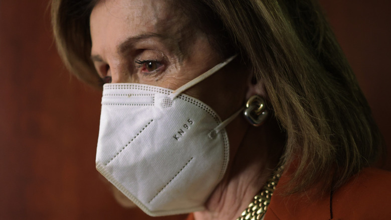 Nancy Pelosi wearing a mask looking stressed