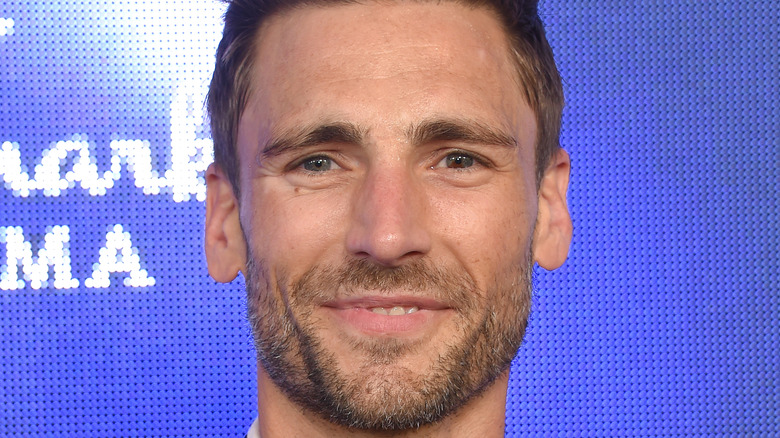 andrew walker smiling in front of purple background