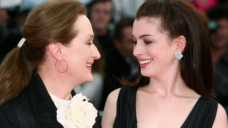 Meryl Streep and Anne Hathaway smiling at each other in 2006
