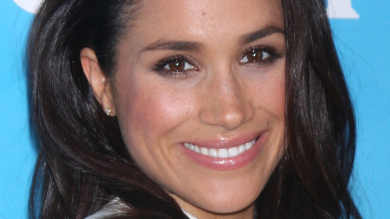 meghan markle smiling on blue background