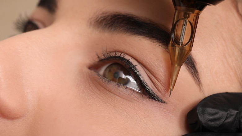 Woman getting a permanent eyeliner tattoo 