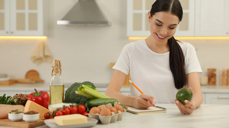 woman writing near food