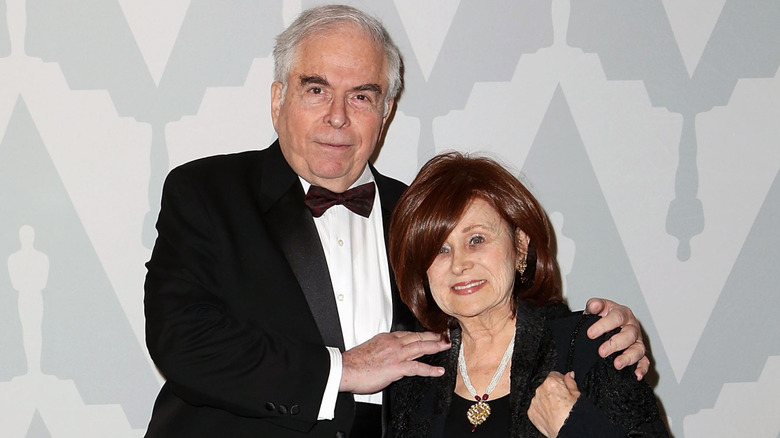 Jordan Charney standing with his arms on his wife's shoulders at a 2014 dinner and viewing party