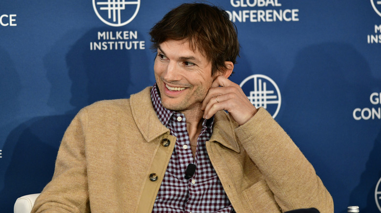 Ashton Kutcher smiling on panel at the 2023 Milken Institute Global Conference