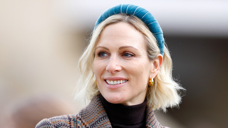 Zara Tindall wears a blue headband and smiles