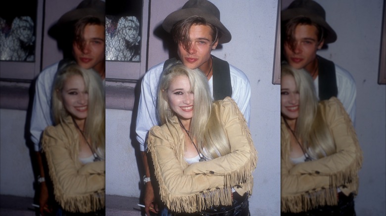 E.G. Daily standing in front of Brad Pitt with her arms crossed, smiling.