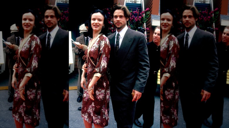 Brad Pitt and Juliette Lewis dressed up posing next to each other.