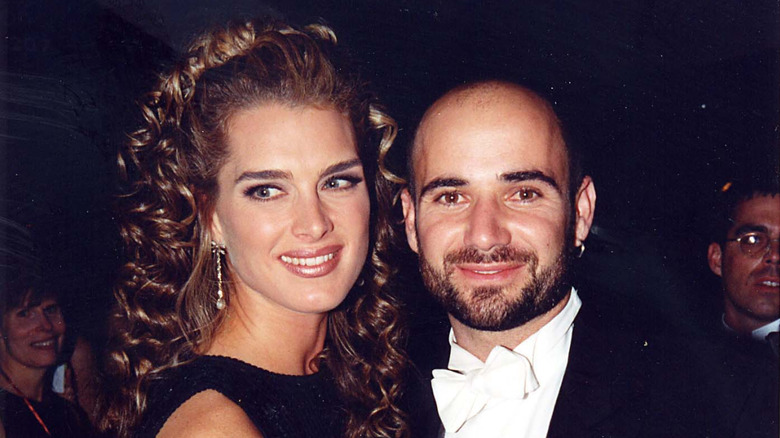 Brooke Shields and Andre Agassi embrace as they smile at a red carpet event