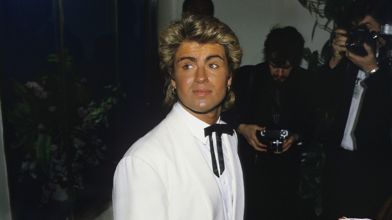 A young George Michael glances away from photographers