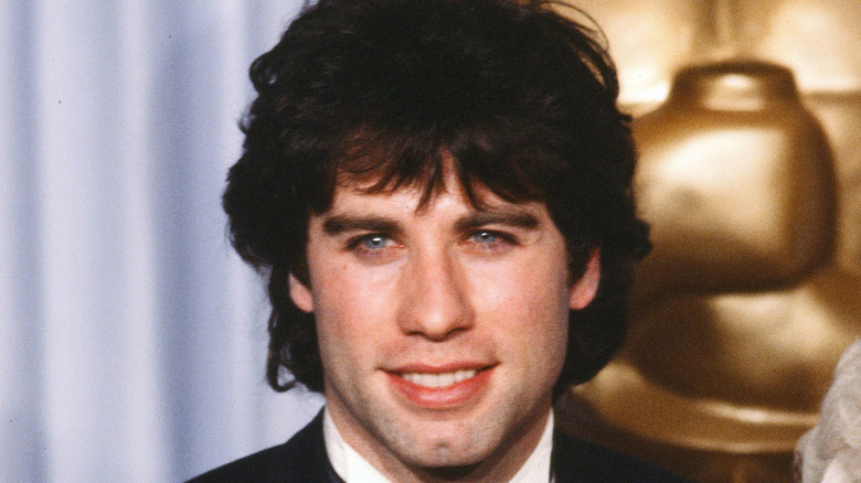 A young John Travolta smiles for a photo at a red carpet event