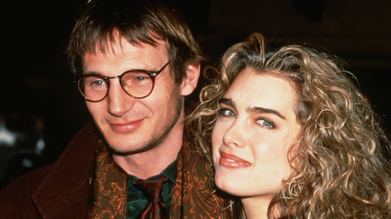 A young Liam Neeson places his arm around Brooke Shields as they pose for a photo