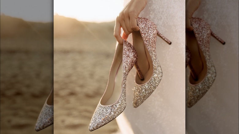 woman holding sleek sparkly pump
