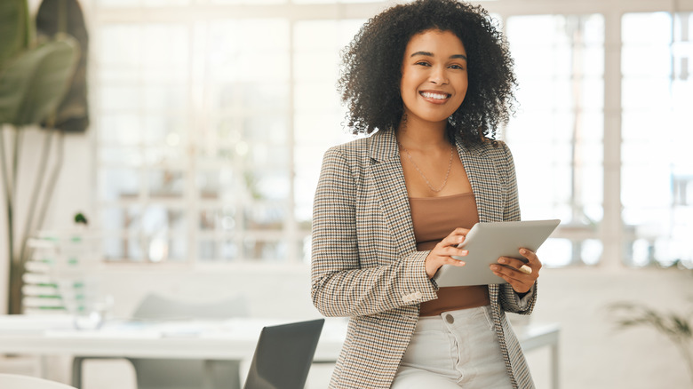 woman sitting on desk smiling