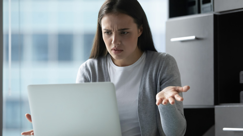 woman confused in front of laptop