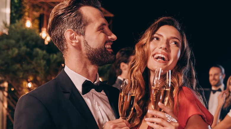 Couple smiling at party cheersing