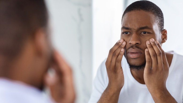 Man looking at the circles under his eyes