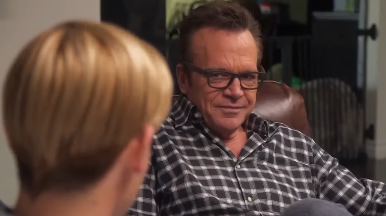 Tom Arnold staring skeptically at Tyler Henry
