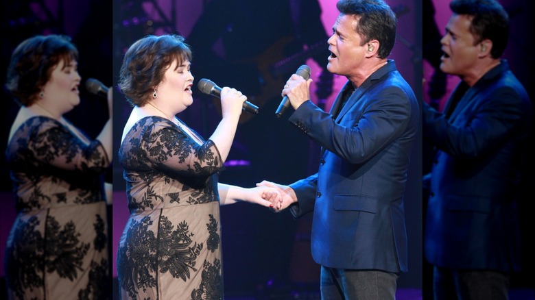 Susan Boyle and Donny Osmond singing together, clasping hands