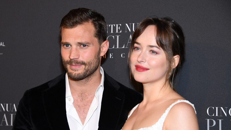 jamie dornan and dakota johnson smile on the red carpet