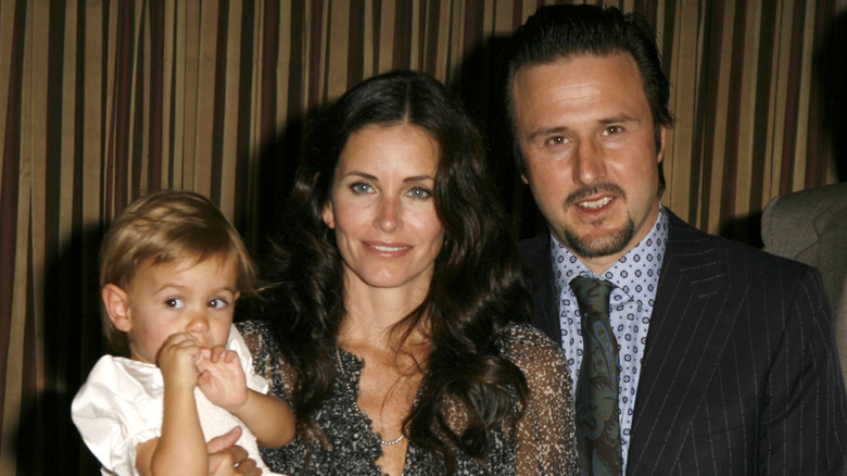 David Arquette, Courteney Cox, and daughter Coco posing and smiling.