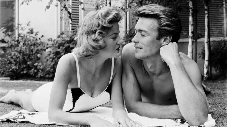 Maggie Johnson, wearing a swimsuit, and her husband, American actor and film director Clint Eastwood, gaze into each other's eyes in the garden of their home in Los Angeles, California, 9th June 1956.