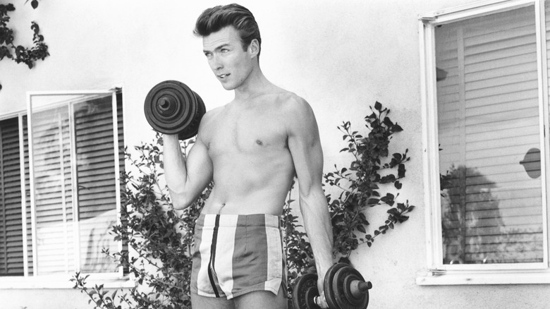 Clint Eastwood works out with dumbbells at home on June 1, 1956 in Los Angeles, California.