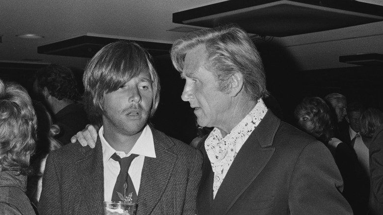 Black and white photo of Lloyd Bridges speaking to a dazed-looking Beau Bridges circa 1971.
