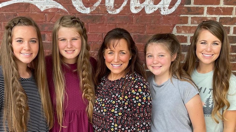 The Duggar women pose against a brick wall