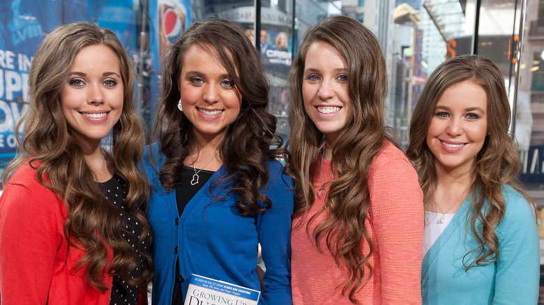Jessa, Jinger, Jill, and Jana Duggar posing with their book "Growing Up Duggar"