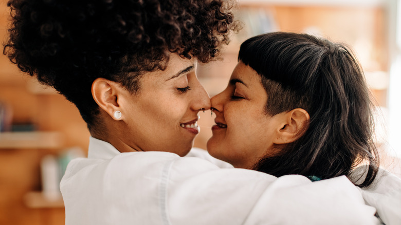 women embracing, touching noses