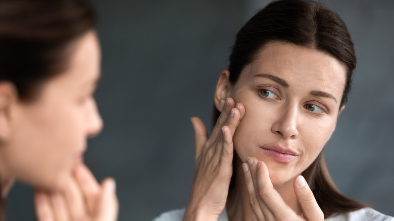 woman touching face skeptically